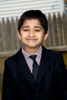 A handsome indian kid formally dressed in a suit