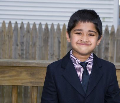 A handsome indian kid formally dressed in a suit