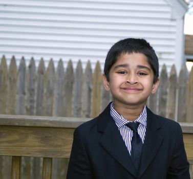 A handsome indian kid formally dressed in a suit