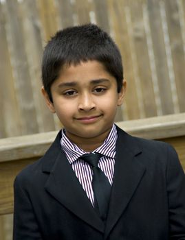 A handsome indian kid formally dressed in a suit