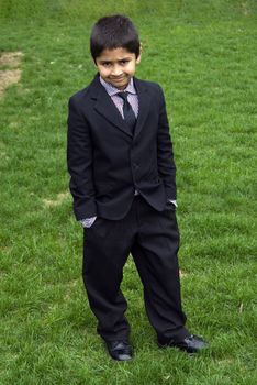 A handsome indian kid formally dressed in a suit