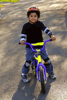 A young indian kid having fun riding a bike