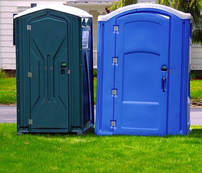 Two portable bathrooms on a cloudy overcast day