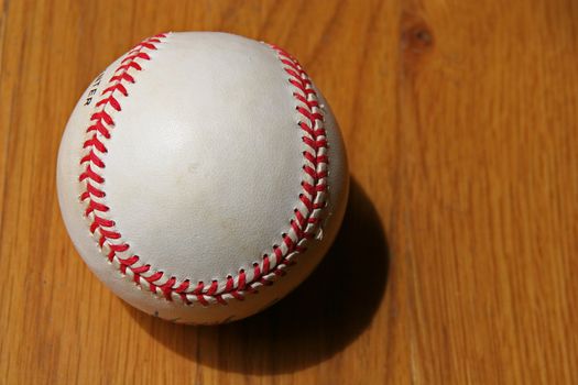 A slightly Worn baseball on wood background