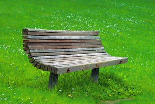 an old  park bench isolated on grass back ground