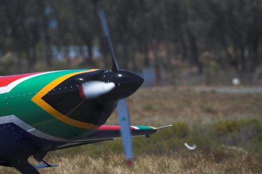 A prop plane with the nose painted in the colors of the South African Flag