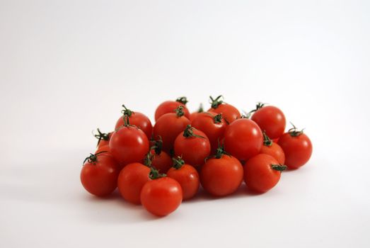 Fresh cherry tomatoes loose on white background.