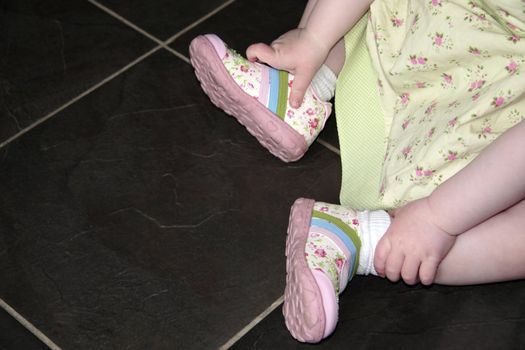 a little baby girl looking at her first new shoes