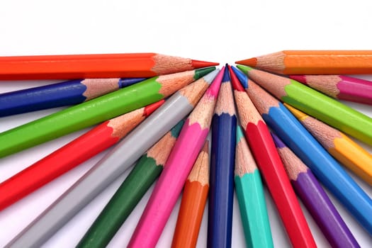 Colored pecnils in semicircle on white