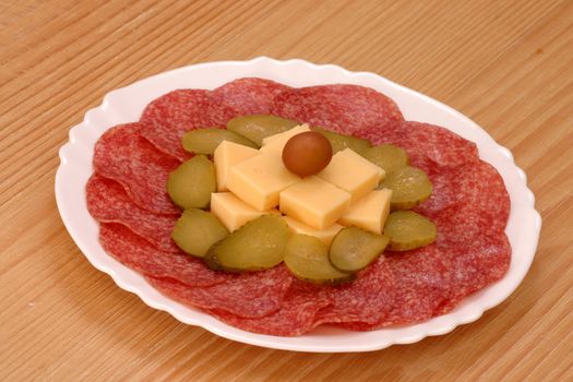 Salami on plate decorated with cheese and cucamber