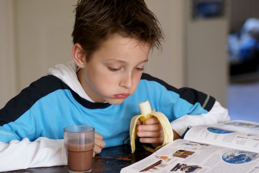 Young boy reading an encyclopedia.