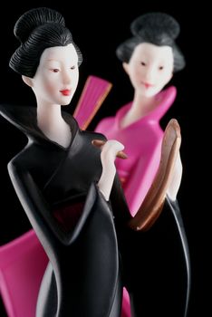 Two beautiful chinese ladies isolated on a black background.