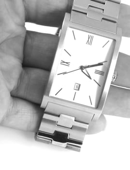 Close up of a hand holding a watch, in black and white.