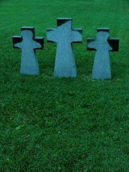Three crosses on a meadow in cemetary