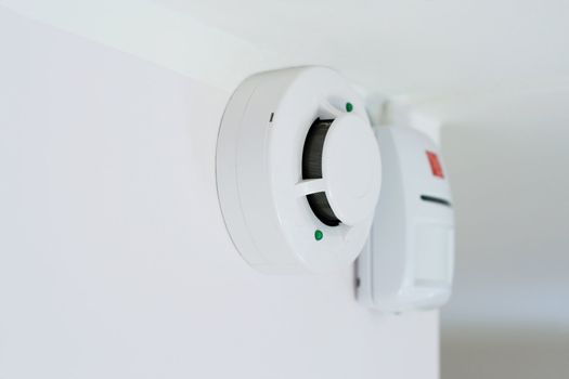 smoke detector and alarm mounted on a wall, shallow DOF