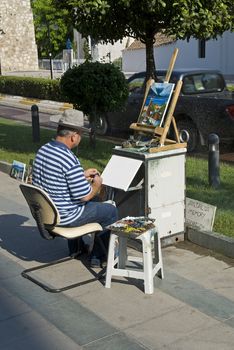 Artist is painting at the street.