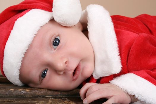 Beautiful six week old baby boy wearing a Christmas suit