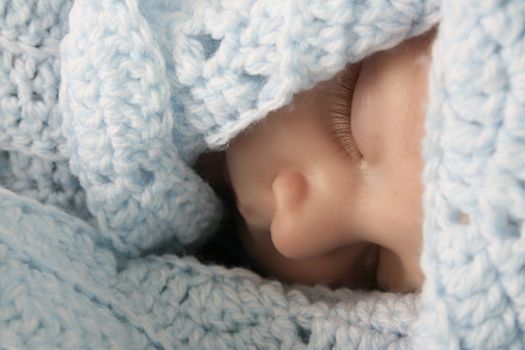 Two month old baby boy wrapped in a blue blanket