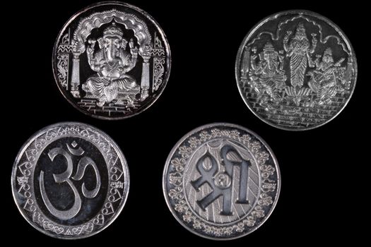 Silver coins with designs of hindu religious symbols and gods for religious ceremonies.