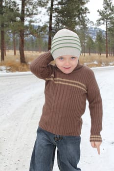 Warmly dressed boy playing outside in the snow