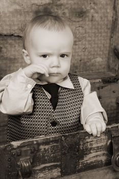 Baby boy playing inside an antique trunk