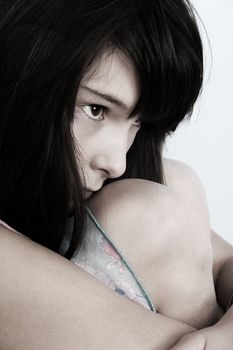 Beautiful brunette teenager with her legs curled up against body