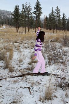Young brunette teen playing in the field after the snowfall
