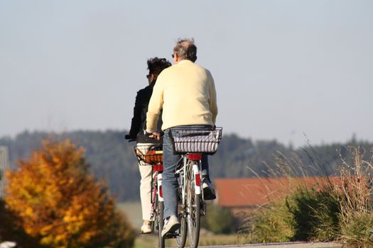 An old married couple ride with bicycle 