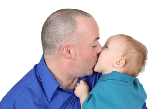 Baby boy kissing his dad holding onto his shirt