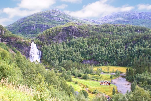 Landscape with a waterfall and houses in the Norwegian mountains