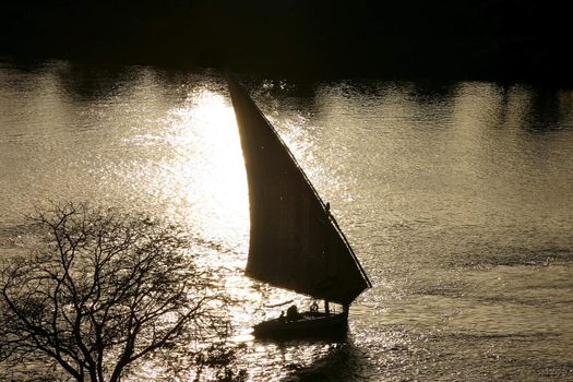 Faluka boat on nile against afternoon sun in Egypt