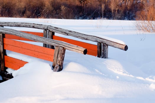 Small wooden bridge in snow
