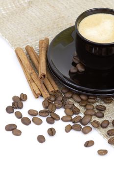 cup of italian espresso with cinnamon and coffee beans