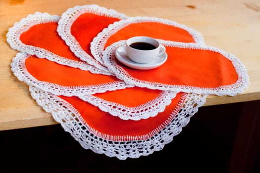 A coffee cup on several orange napkins
