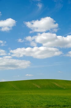 Farm landscape with blue sky and clouds.