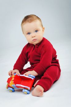 baby boy plaing his toy car in studio