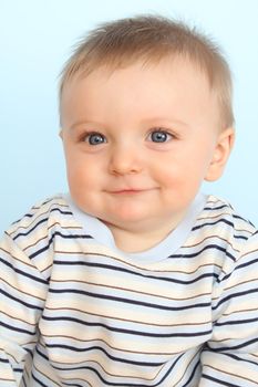 Beautiful 6 month old baby boy against blue background