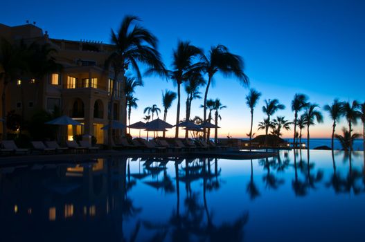 Mirror image of resort in the swimming pool in the early morning in Mexico.