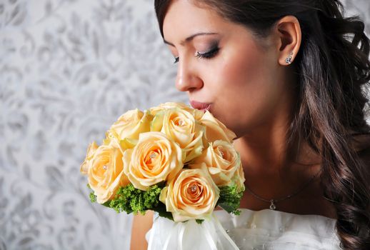 A lovely bride looks down at her bouquet. 