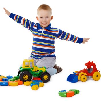 Little boy playing with colorful toys on the floor