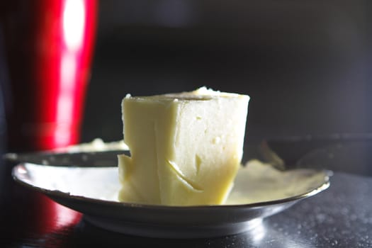 piece of butter with nife on small plate
