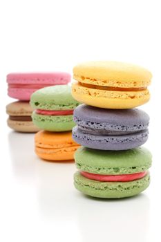 The delightful light fluffy texture melt in the mouth with a little bit of crunch and with a smooth buttercream filling - Mmmm macaroons.  Stacked on a white background. Various colours.