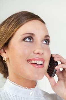 Head portrait of young smiling businesswoman talking on cellphone