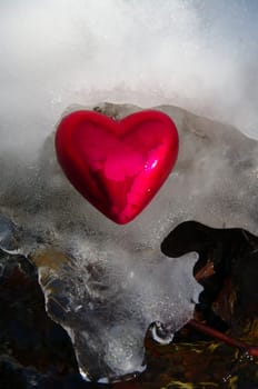 a red  heart on a real snowy icy surface