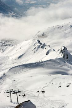 Snowy high mountains with ski lift in winter