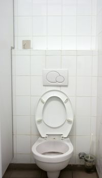 Toilet inside, one seat, white wall, tiles