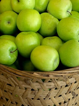 close up of a basket of green apples
