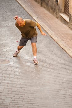 Traditional Spanish sportsman performing a powerful serve at a pelota match