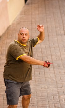 Traditional Spanish sportsman performing a powerful serve at a pelota match