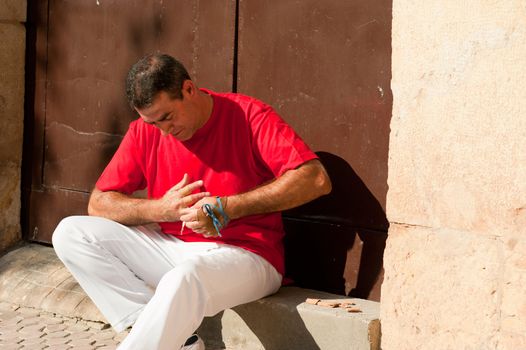 Traditional Spanish pelota player ritually wrapping his fingers in plaster protections